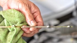 man holding an oil change dipstick